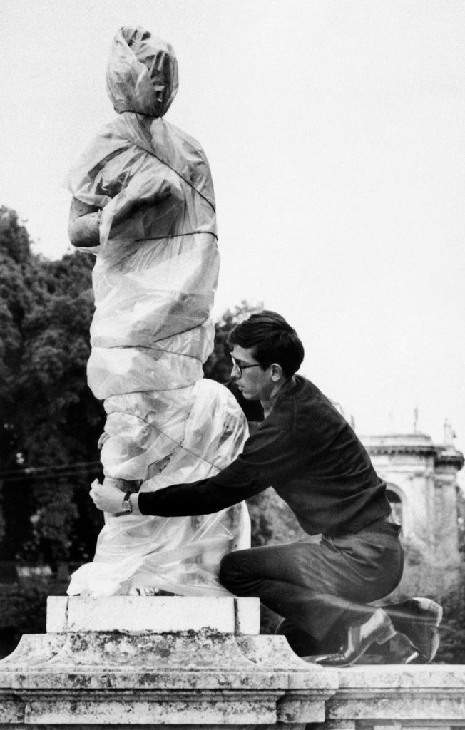 11/29/1963, Rome, Italy- Demostrating his wrap-it art, Christo applies a polythene sheet to an ancient sculpture in Rome. With the plastic sheet and some string, Christo explains, "The sculpture takes on the loving form of mystery." | Image by � Bettmann/CORBIS