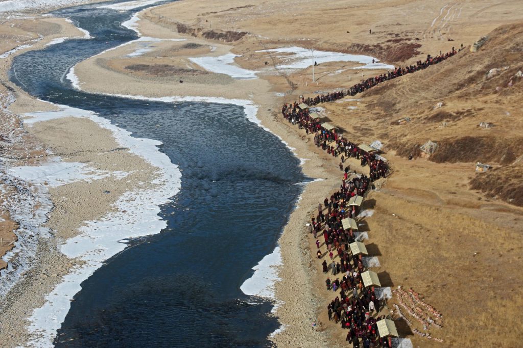 Jian Luo, A queue of pilgriming Tibetans by the riverside during the Tibetan New Year, Yarchen Gar, Garzê, 2019