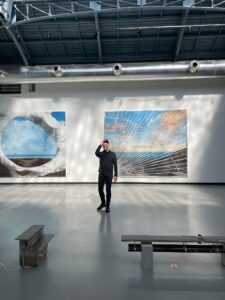 Curator Joël Riff at La Verrière, the exhibition space of Fondation d’Entreprise Hermès in Brussels, during Aster, the exhibition featuring works by Eva Nielsen (background) and Arnaud Eubelen (foreground). Photo: Laurent Peyoux.