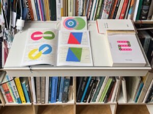 Detail bibliotheek met boekenkast van Nils Holger Moormann en uitstalling van boekje en kalender van Karel Martens.