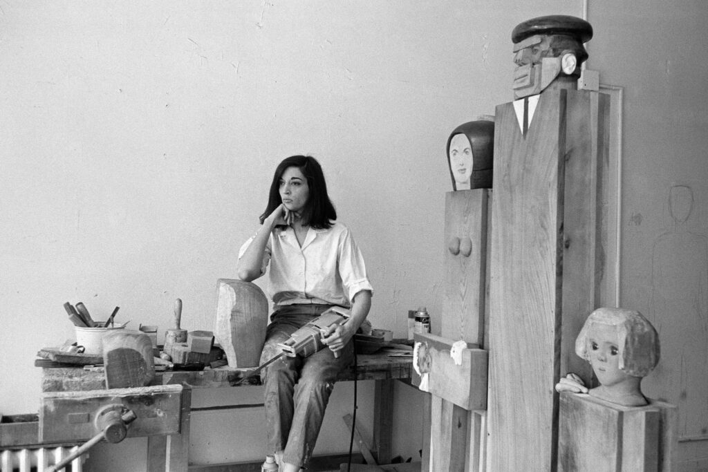 Marisol Escobar met haar sculptuur The Kennedyʼs, 1964 | © foto: Sam Falk