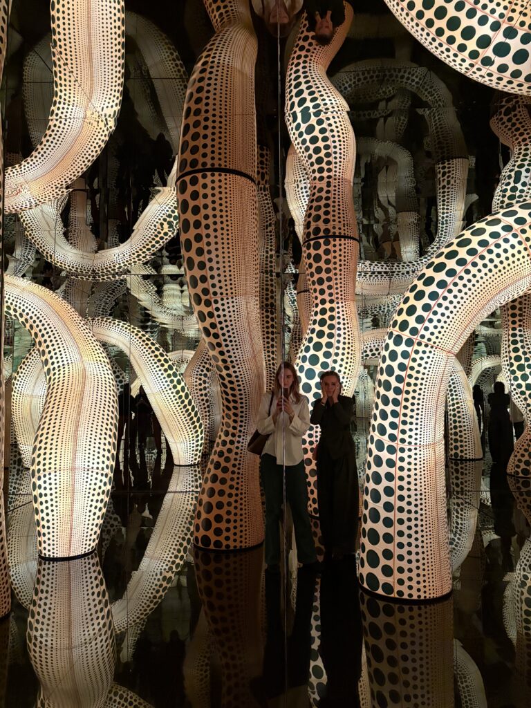 Nicole Ex (rechts) en Sarah Knigge (links) ergens tussen spiegelbeeld, stippen en oneindigheid in Yayoi Kusama’s nieuwe Infinity Mirror Room in het Stedelijk Museum Amsterdam, 9 september 2026